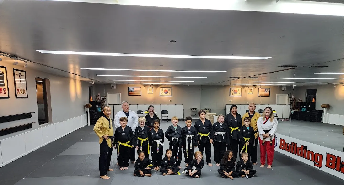 Masters in gold uniforms with the black belt team at Oh's Martial Arts in Seminole